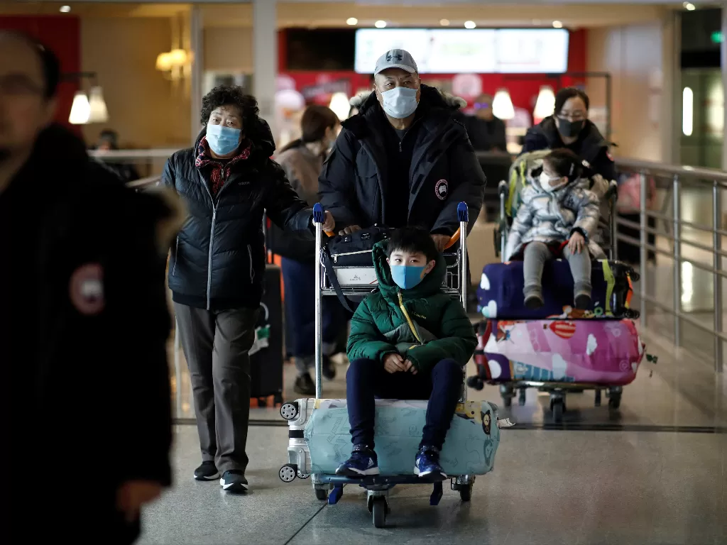 Wisatawan yang memakai topeng tiba dengan penerbangan langsung dari Tiongkok, di Paris. (Photo/REUTERS/Benoit Tessier)