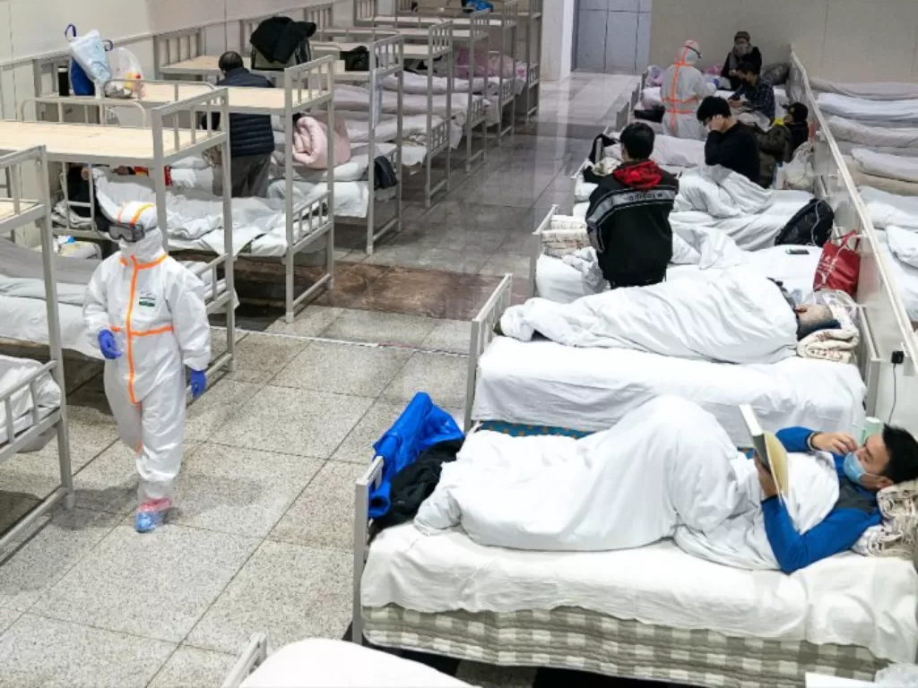 Pekerja medis yang mengenakan pakaian pelindung mendatangi pasien di Pusat Konferensi dan Pameran Internasional Wuhan. (Photo/REUTERS/China Daily)