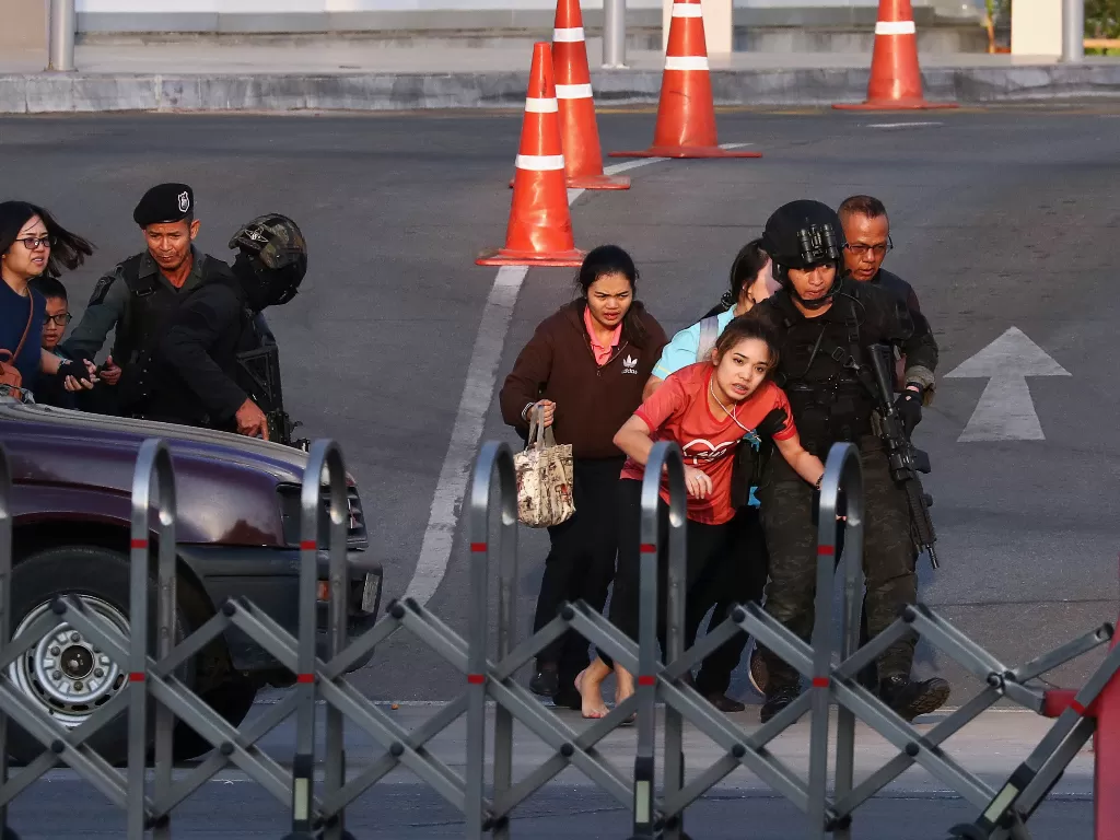 Pasukan keamanan Thailand mengevakuasi warga yang terdampar di dalam pusat perbelanjaan Terminal saat penembakan massal, Minggu (9/2/2020). photo/REUTERS/Athit Perawongmetha