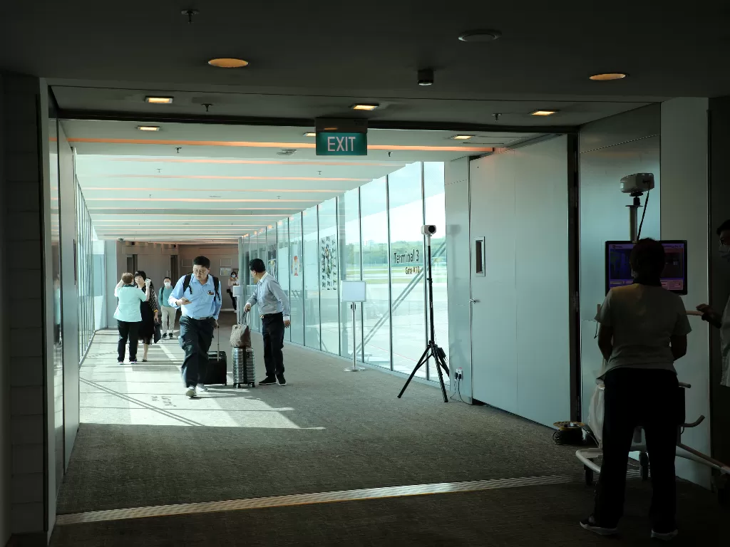 Petugas memantau kamera thermal ketika para penumpang dari penerbangan asal Hangzhou, Tiongkok tiba di Bandara Changi Singapura, Rabu (22/1). (REUTERS/Yiming Woo)
