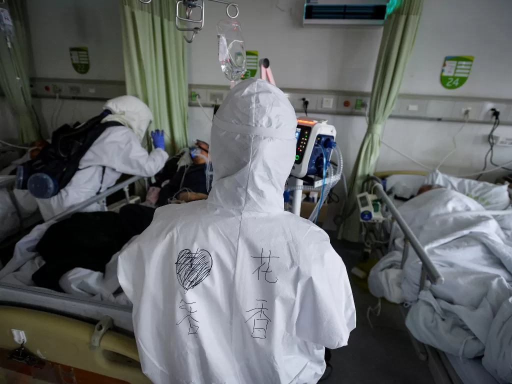 Ilustrasi: Pekerja medis dalam pakaian pelindung memeriksa pasien coronavirus di dalam bangsal terisolasi di rumah sakit di Wuhan (China Daily)