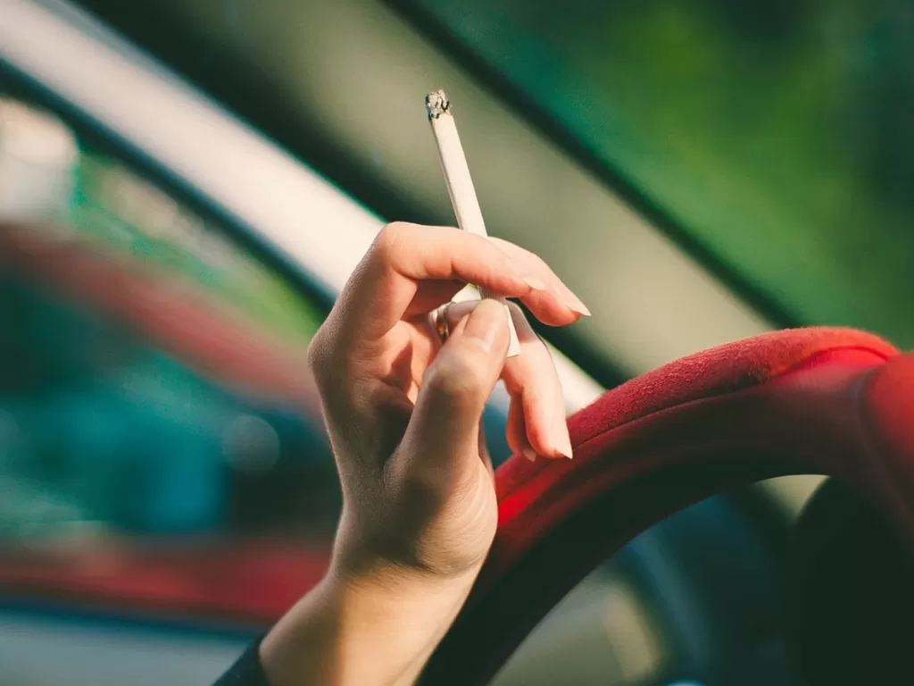 Ilustrasi merokok saat berkendara (Unsplash)