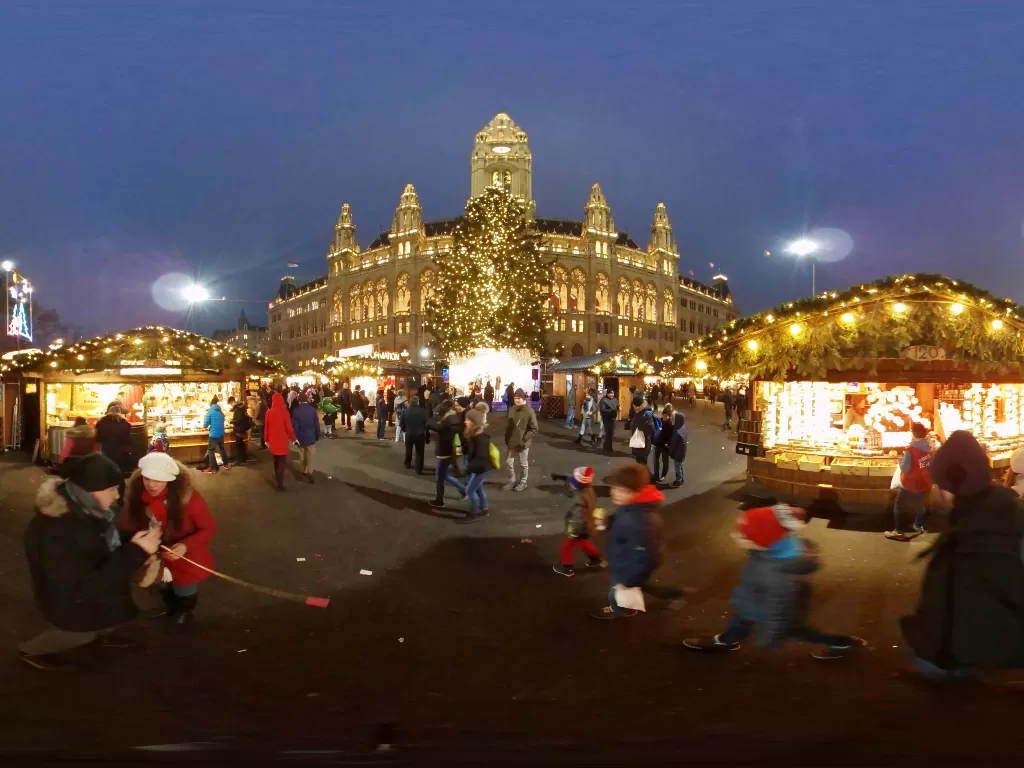 Hilir mudik pengunjung di pasar Natal di depan balai kota Wina di Wina, Austria. (REUTERS/Leonhard Foeger)
