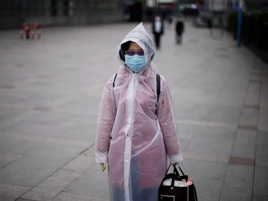Seorang wanita menggunakan masker dan kacamata renang untuk mencegah tertular virus korona ketika berjalan di Shanghai, Tiongkok (Ilustrasi/REUTERS/Aly Song).