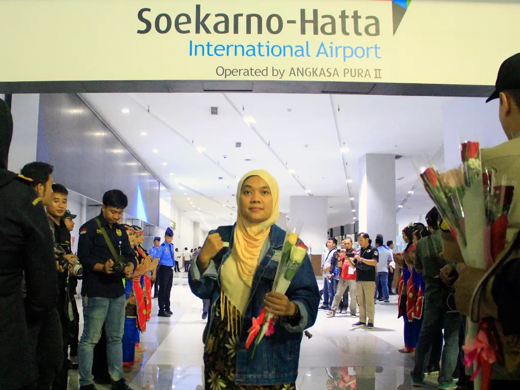 Sejumlah petugas bandara memberikan bunga kepada penumpang perdana yang mendarat di tahun 2020 di Bandara Soekarno Hatta, Tangerang, Banten, Rabu (1/1/). (ANTARA FOTO/Muhamad Iqbal)