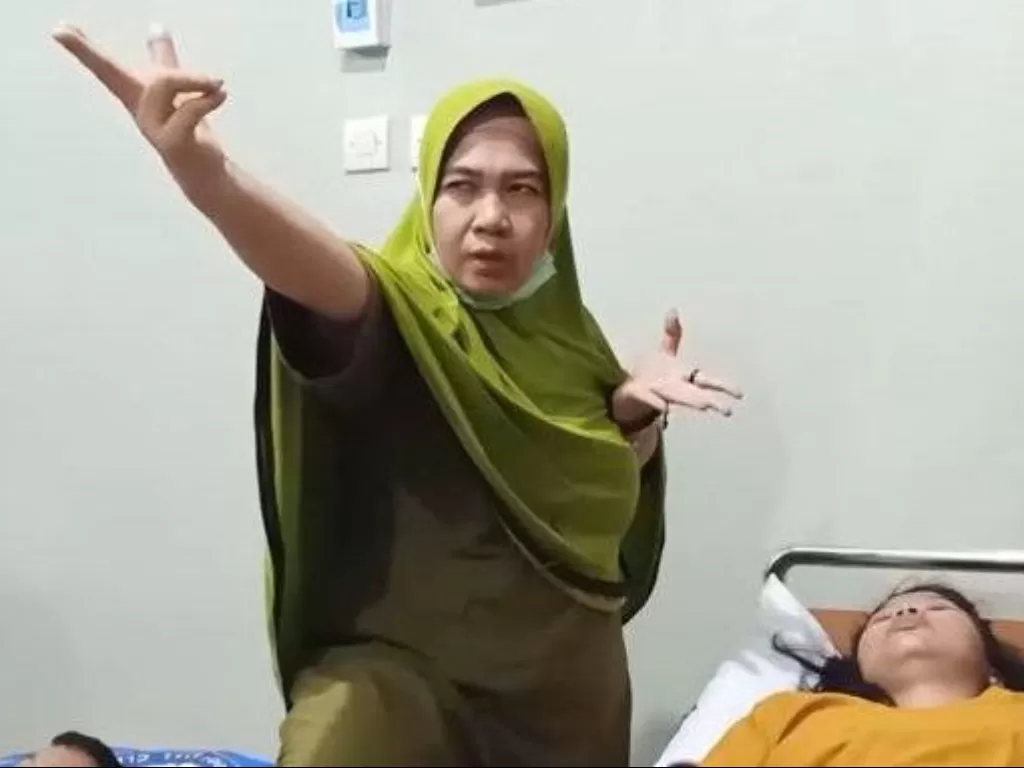 Ningsih Tinampi saat mengobati pasiennya. (YouTube)