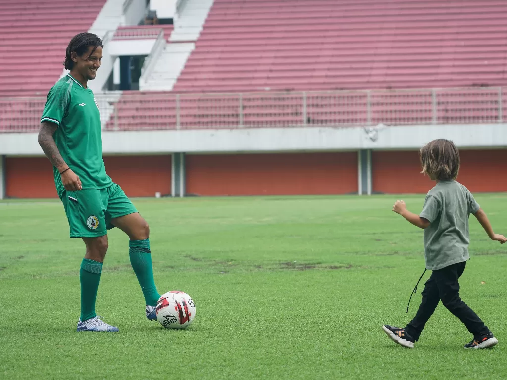 Pesepak bola PS Sleman Irfan Bachdim bermain bola dengan anaknya usai sesi perkenalan pemain baru di Stadion Maguwoharjo, Sleman, DI Yogyakarta, Rabu (12/2/2020). (ANTARA FOTO/Hendra Nurdiyansyah)