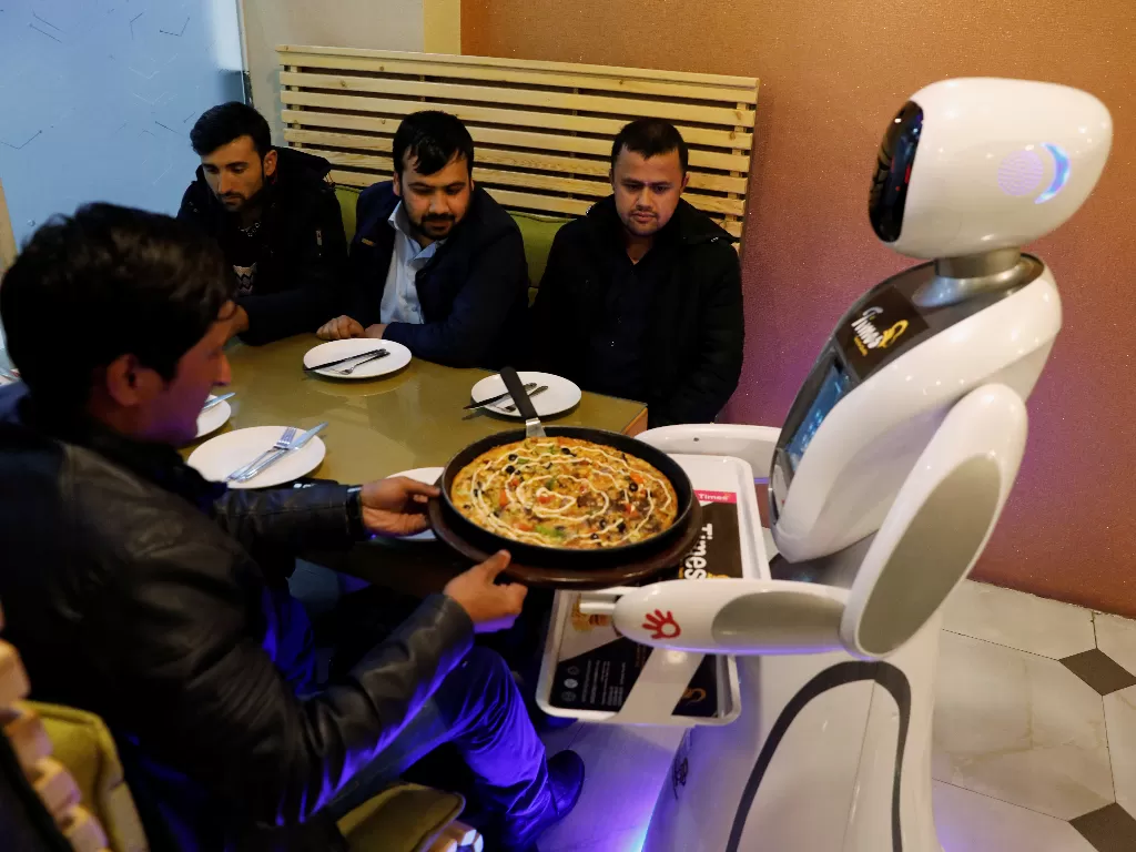 Robot pelayan Timea mengantarkan makanan ke sebuah meja di restoran Times, Kabul, Afghanistan, Selasa (11/2/2020). (REUTERS/Mohammad Ismail)