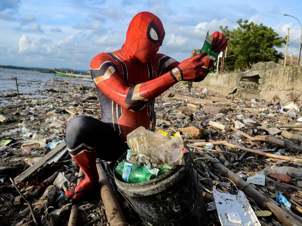 Rudi Hartono, seorang pria berpakaian kostum Spiderman, melihat sampah plastik saat ia mengumpulkan sampah di sebuah pantai di Pare-Pare, provinsi Sulawesi Selatan. (photo/Reuters/Stringe)