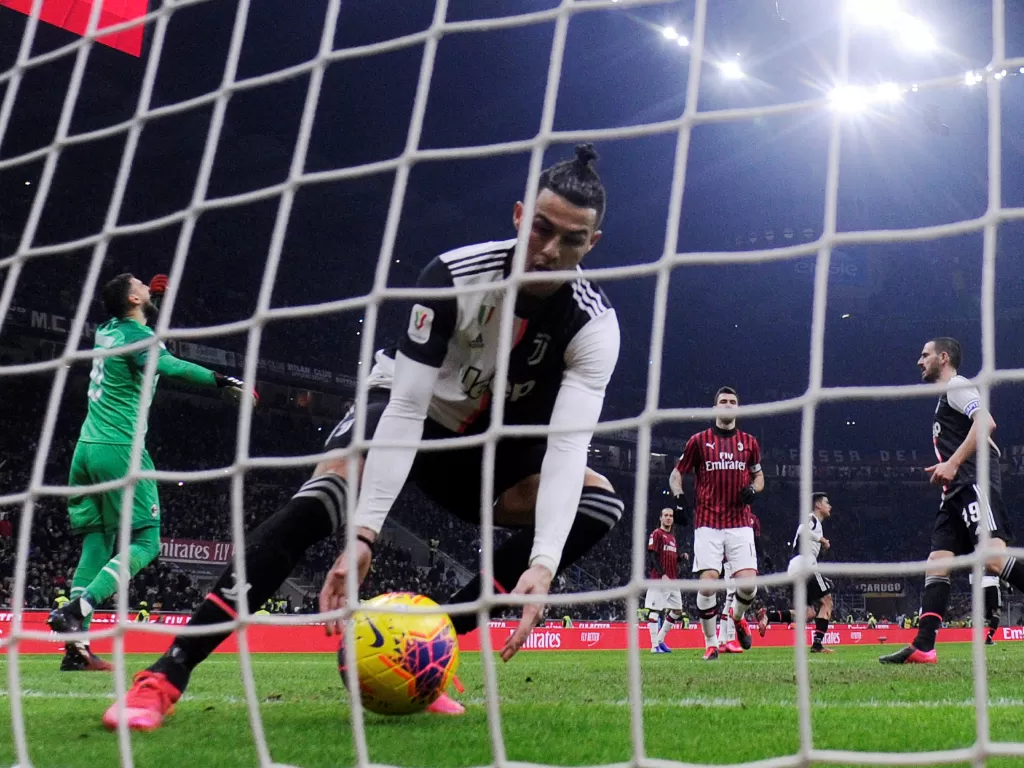 Penyerang Juventus, Cristiano Ronaldo memungut bola dari gawang setelah sukses melakukan tendangan penalti. (REUTERS/Alberto Lingria)