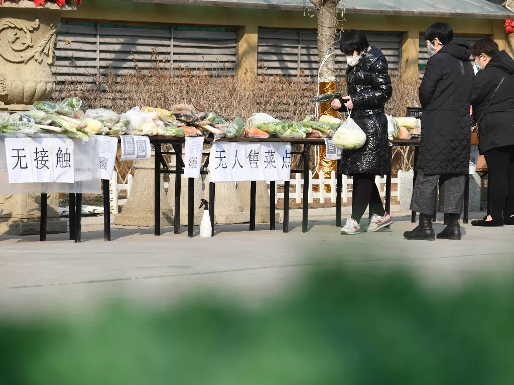 Warga membeli sayuran di kios sayur tak berpenjaga di sebuah permukiman di Distrik Xinhua, Shijiazhuang, ibu kota Provinsi Hebei, Tiongkok Utara, Rabu (12/2/2020). (Xinhua/Xu Jianyuan)