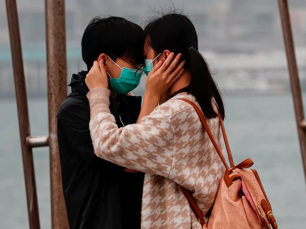 Pasangan memakai masker pada Hari Valentine setelah pecahnya virus corona baru di Hong Kong, Tiongkok, Jumat (14/2/2020). (REUTERS/Tyrone Siu)