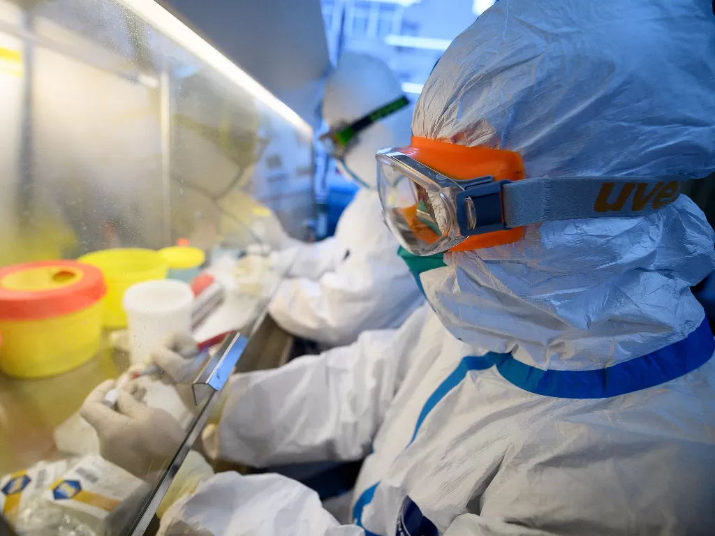 Ilustrasi: Pekerja dengan pakaian pelindung melakukan tes RNA pada spesimen di dalam laboratorium di pusat pengendalian dan pencegahan penyakit di Taiyuan (REUTERS)