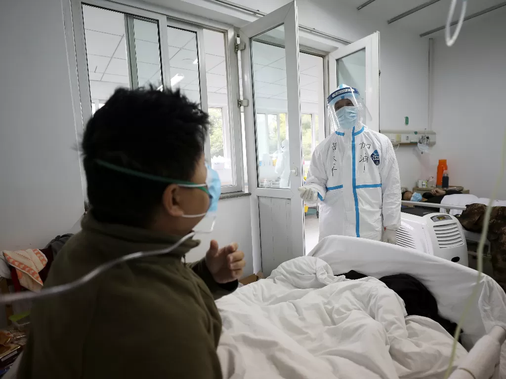 Ilustrasi: petugas medis menggunakan pakaian pelindung berinteraksi dengan pasien di dalam bangsal terisolasi di Rumah Sakit Jinyintan di Wuhan (China Daily)