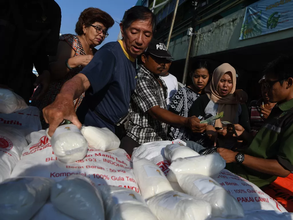 Warga mengantri membeli gula pasir saat digelar pasar murah gula pasir RMI dengan harga Rp11.500 per Kg di Surabaya, Jawa Timur, Rabu (22/1/2020). (ANTARA FOTO/Zabur Karuru)