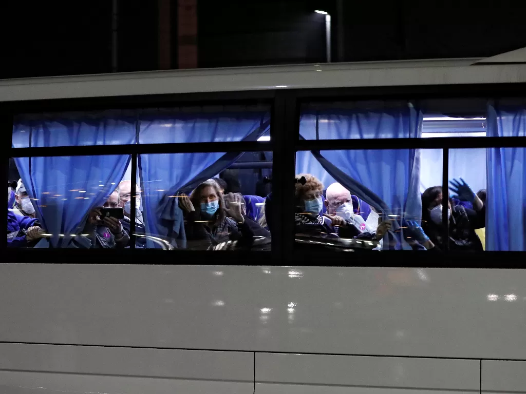 Bus yang mengangkut penumpang AS dari kapal pesiar Diamond Princess, tempat puluhan penumpang dinyatakan positif terkena virus corona, berangkat ke Daikoku Pier Cruise Terminal di Yokohama, selatan Tokyo, Jepang, Minggu  (16/2/2020). (REUTERS/Athit Perawo