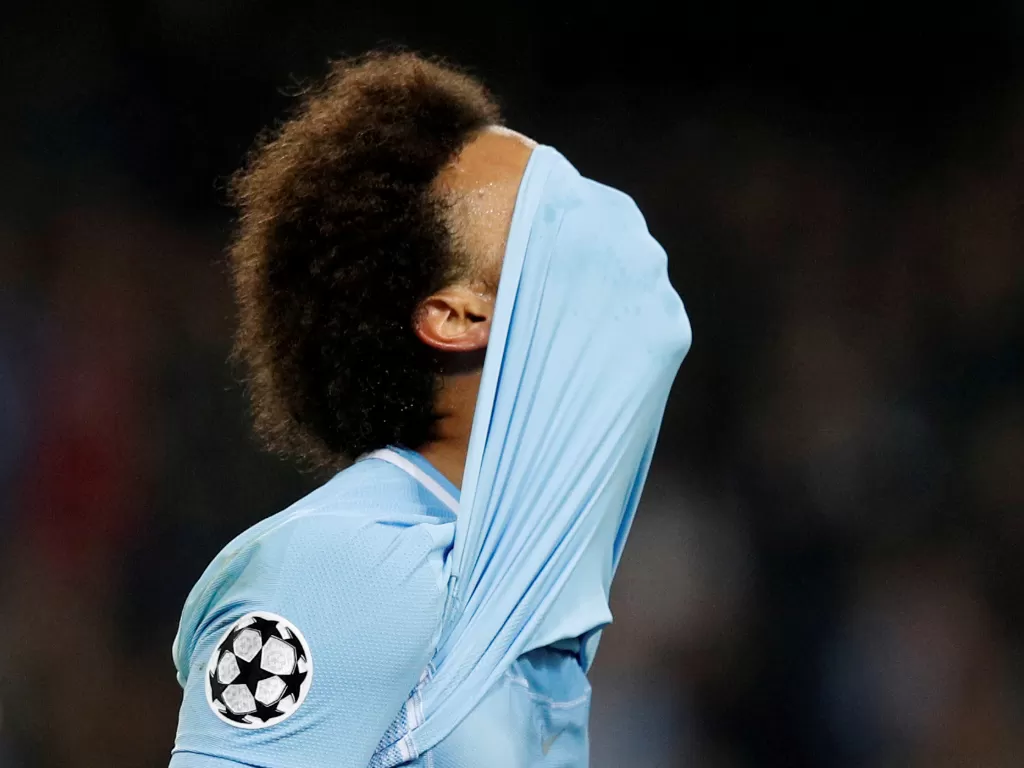 Pemain Manchester City Leroy Sane menutup wajahnya dengan jersey. (REUTERS/Phil Noble)