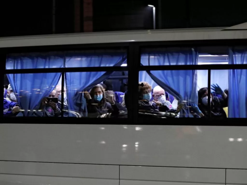 Bus yang mengangkut penumpang AS dari kapal pesiar Diamond Princess, tempat puluhan penumpang dinyatakan positif terkena virus corona, berangkat ke Daikoku Pier Cruise Terminal di Yokohama, Jepang, Minggu (16/2/2020). (REUTERS/Athit Perawo)
