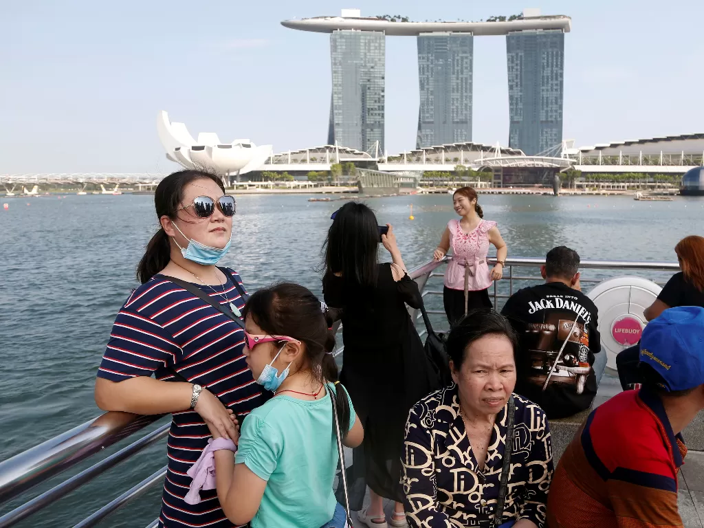 Sejumlah wisatawan yang berfoto di depan Teluk Marina, Singapura, (REUTERS/Feline Lim)
