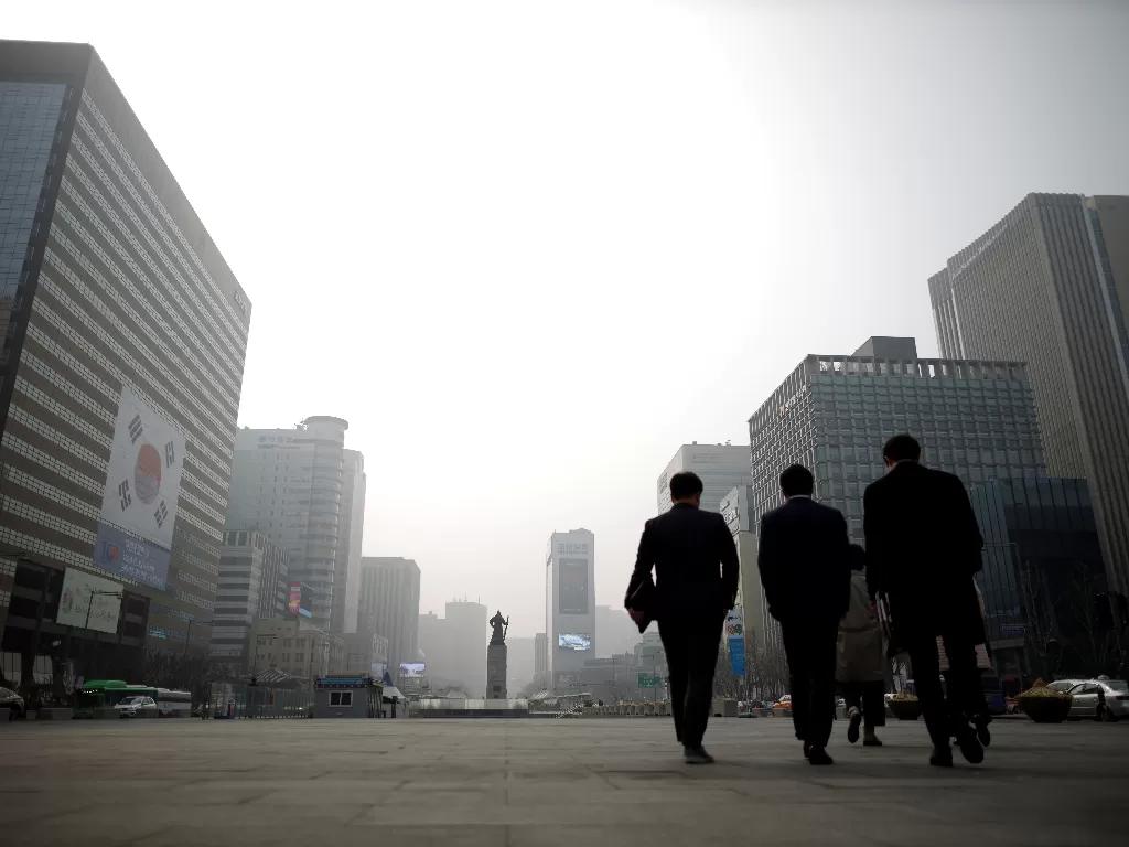 Tiga orang pekerja berjalan di sebuah kawasan pedesterian di kota Seoul, Korea Selatan. (REUTERS)