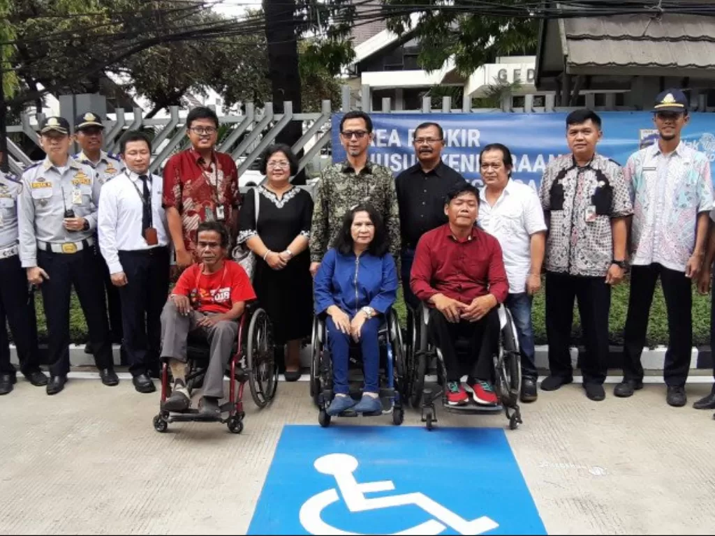 Direktur Operasi dan Pemeliharaan PT MRT Jakarta Muhammad Effendy berfoto bersama sejumlah penyandang disabilitas dalam acara pembukaan area parkir khusus disabilitas di Stasiun MRT Lebak Bulus Grab, Jakarta, Kamis (20/2/2020). (ANTARA/Katriana). 