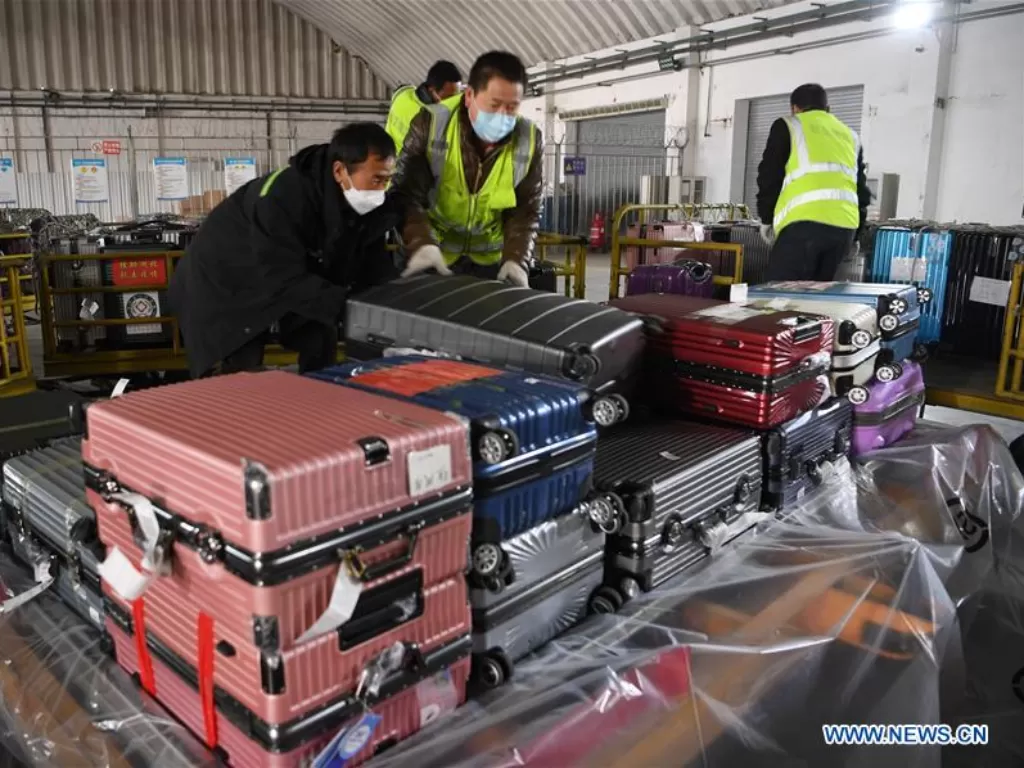 Beberapa pekerja mengangkut barang ke pesawat kargo. (Xinhua/Fan Peishen)