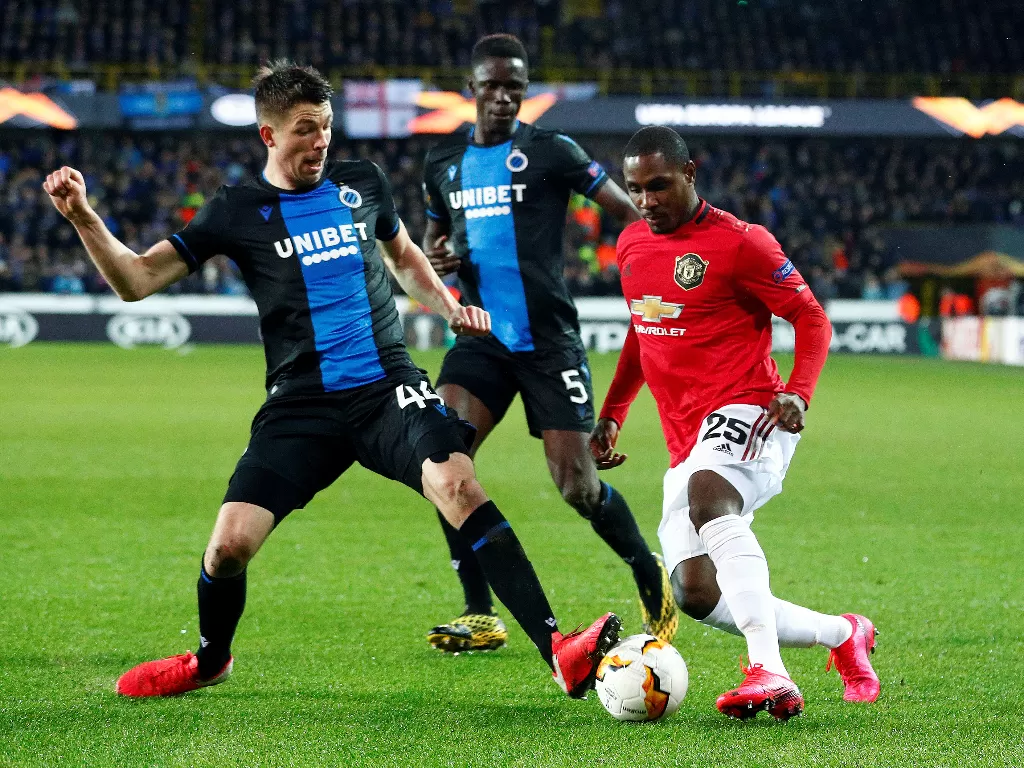 Penyerang Manchester United, Odion Ighalo sedang berusaha melewati dua pemain Club Brugge.  (REUTERS/Francois Lenoir)
