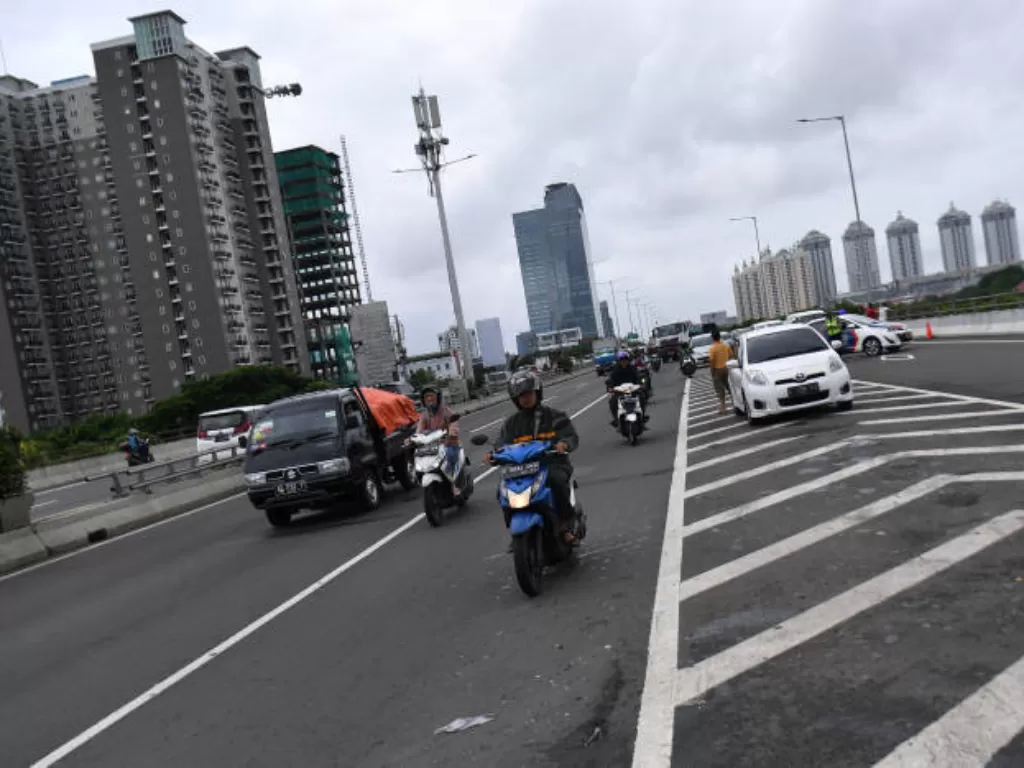 Pengendara sepeda motor melintas masuk ke Jalan Tol Wiyoto Wiyono untuk menghindari banjir di Jakarta Utara, Minggu (23/2/2020). (ANTARA FOTO/Sigid Kurniawan)