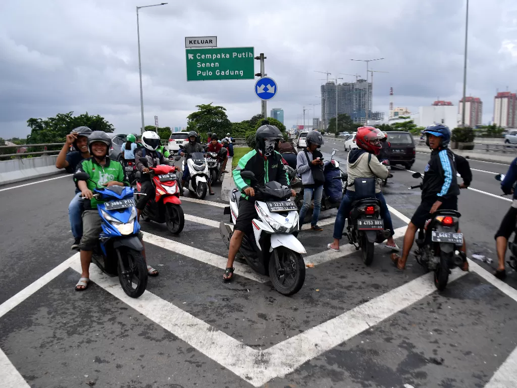 Pengendara sepeda motor masuk ke Jalan Tol Wiyoto Wiyono untuk menghindari banjir di Jakarta Utara, Minggu (23/2/2020). (ANTARA FOTO/Sigid Kurniawan)