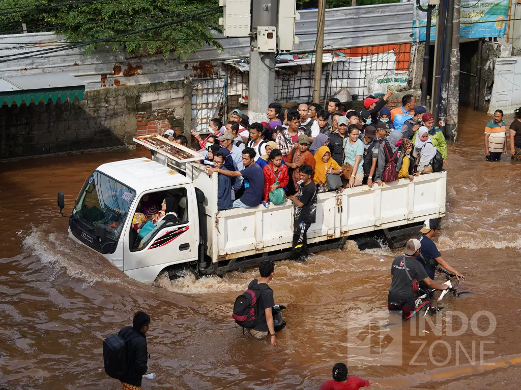 Warga melintasi jalanan yang tergenang banjir di Jalan Daan Mogot, Jakarta, Kamis (2/1/2020). (INDOZONE/Arya Manggala)