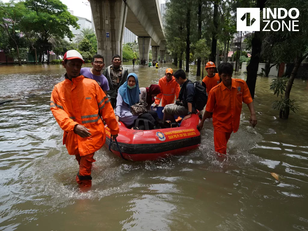 Warga menaiki perahu karet saat melintasi banjir di Jalan Kayu Putih Raya, Jakarta, Selasa (25/2/2020). (INDOZONE/Arya Manggala) 