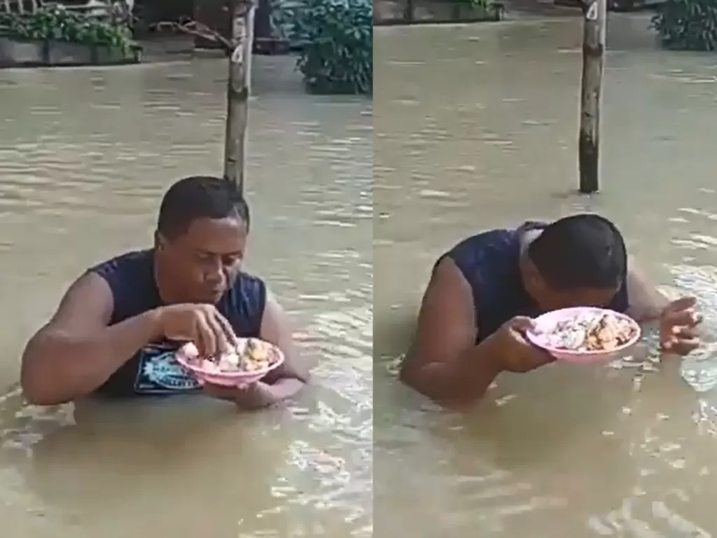 Seorang pria makan di tengah banjir. (photo/Twitter/@Penol86)