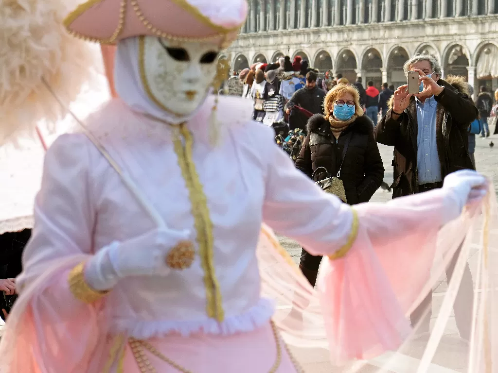 Salah seorang peserta Karnaval Venesia menghibur warga di St. Mark's Square, Venesia, Senin (24/2). (REUTERS/Manuel Silvestri)