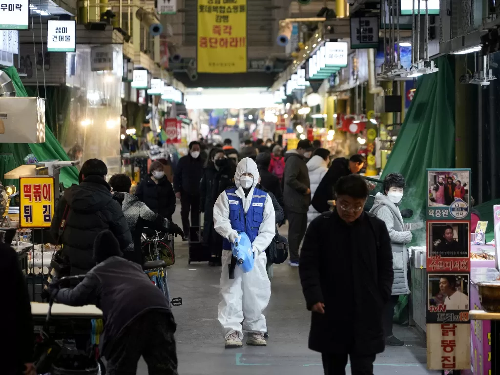 Seorang petugas menyemprotkan cairan disinfektan di sebuah pasar tradisional di Seoul, Senin (24/2). (REUTERS/Kim Hong-ji)
