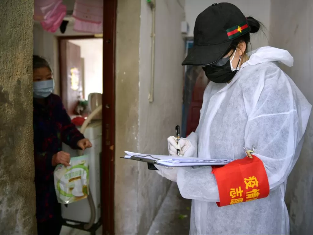 Petugas mengirimkan makanan ke penduduk lokal di Tanhualin, Distrik Wuchang di Wuhan, Tiongkok, (9/2/2020). (XINHUA/Li He)
