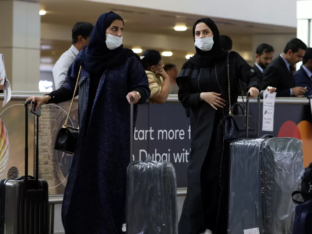 Penumpang di  Dubai International Airport mengenakan masker. (REUTERS/Christopher Pike)