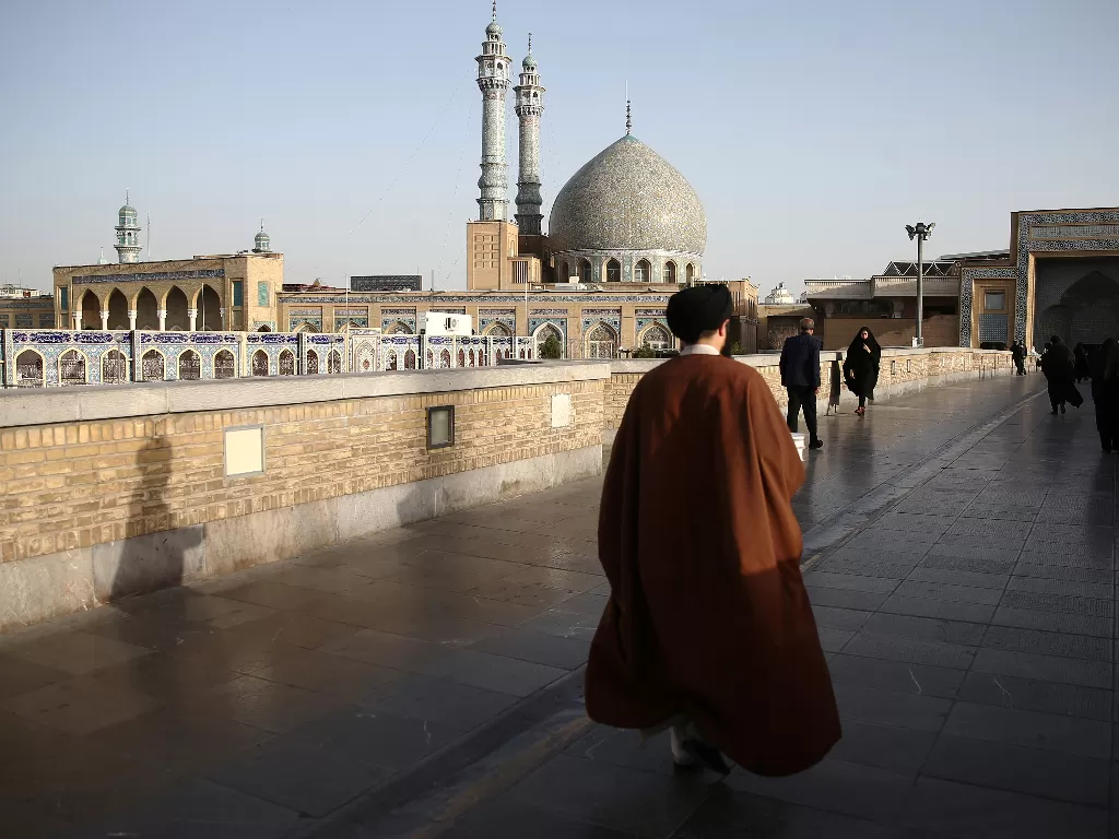 Seorang warga Iran berjalan di depan situs Fatimah Masumeh di kota suci Qom. (REUTERS/Wana)