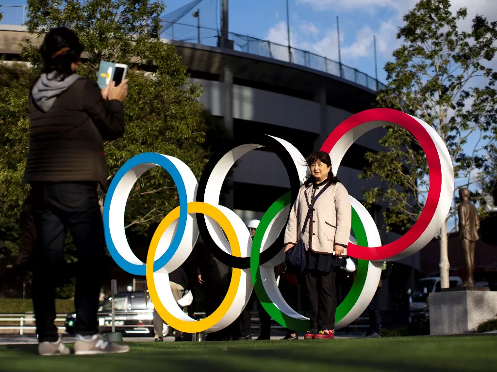 Warga Jepang berfoto di depan lingkaran Olimpiade. (REUTERS/Athit Perawongmetha)