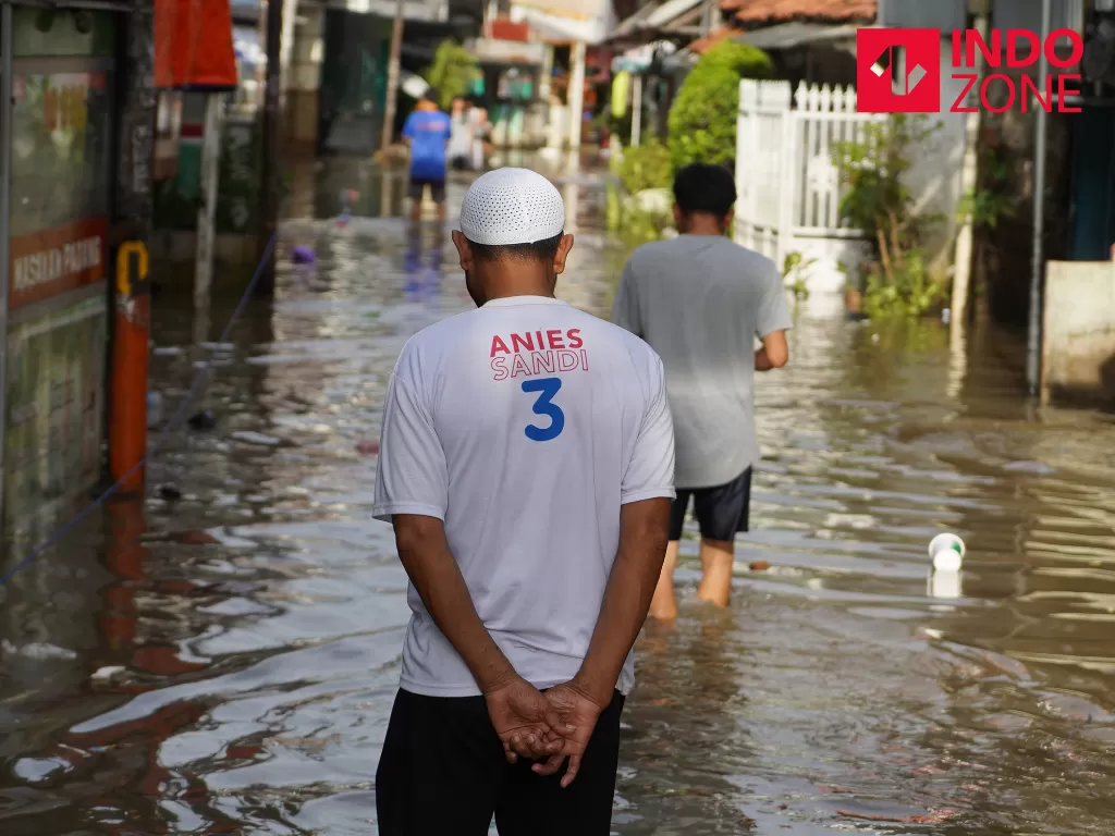 Warga melintasi banjir di kawasan Karet Tengsin, Tanah Abang, Jakarta Pusat, Selasa (25/2/2020). Saat ini DPRD DKI Jakarta tengah memproses pembentukan Pansus Banjir. (INDOZONE/Arya Manggala)