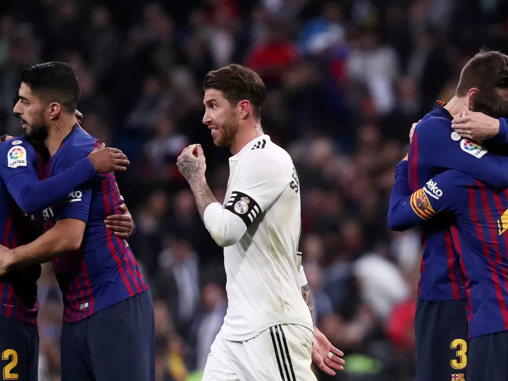 Bek Real Madrid, Sergio Ramos berjalan di antara pemain Barcelona yang merayakan kemenangan dalam laga El Clasico pada 2 Maret 2019. (REUTERS/Sergio Perez)