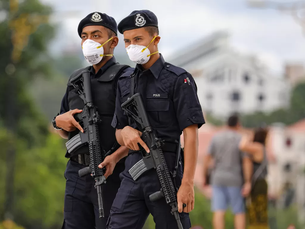 Aparat Malaysia berjaga sambil menggunakan masker (REUTERS/Lim Huey Teng)