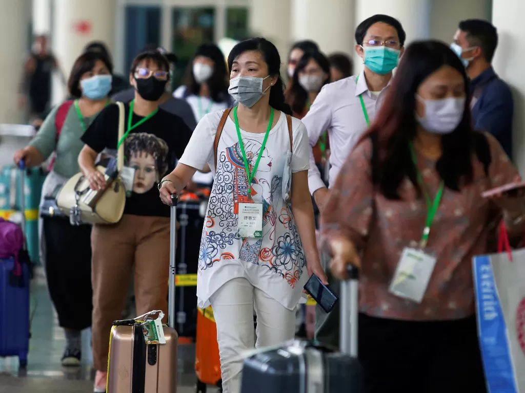 Sejumlah penumpang memakai masker di Bandara Ngurah Rai, Bali. (REUTERS/Johannes P. Christo)