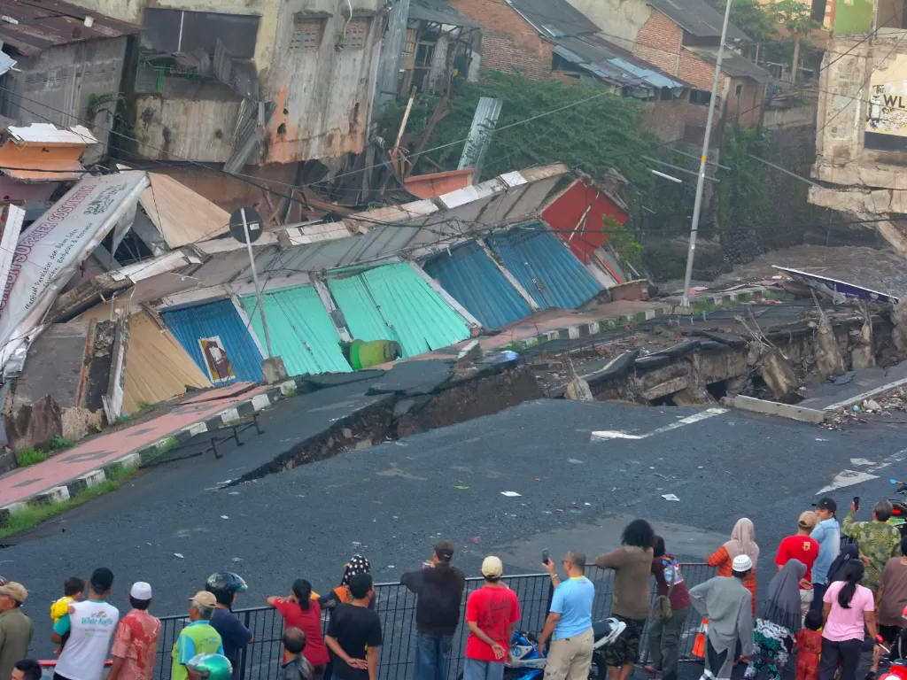 Sejumlah warga melihat pertokoan Jompo yang ambruk di Jalan Sultan Agung Jember, Jawa Timur, Senin (2/3/2020). (ANTARA FOTO/Seno)