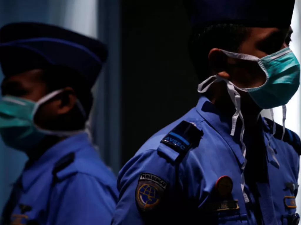 Petugas memakai masker saat berjaga di terminal kedatangan internasional, Bandara Soekarno-Hatta, Tangerang, Banten, Selasa (21/1/2020). (REUTERS/Willy Kurniawan)