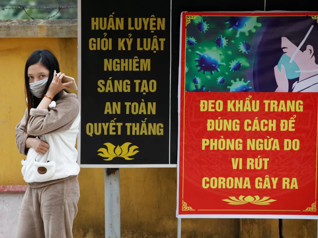 Perempuan Vietnam yang baru kembali dari Tiongkok memakai masker untuk cegah penyebaran virus corona di Vietnam. (REUTERS/Kham)