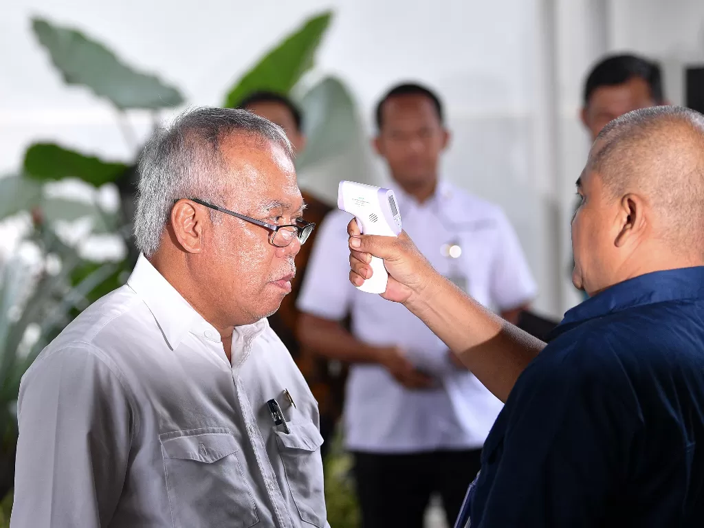  Menteri PUPR Basuki Hadimuljono (kiri) diperiksa suhu tubuhnya sebelum rapat dengan Presiden Joko Widodo di kompleks Istana Kepresidenan, Jakarta Pusat, Selasa (3/3/2020). (ANTARA FOTO/Sigid Kurniawan)