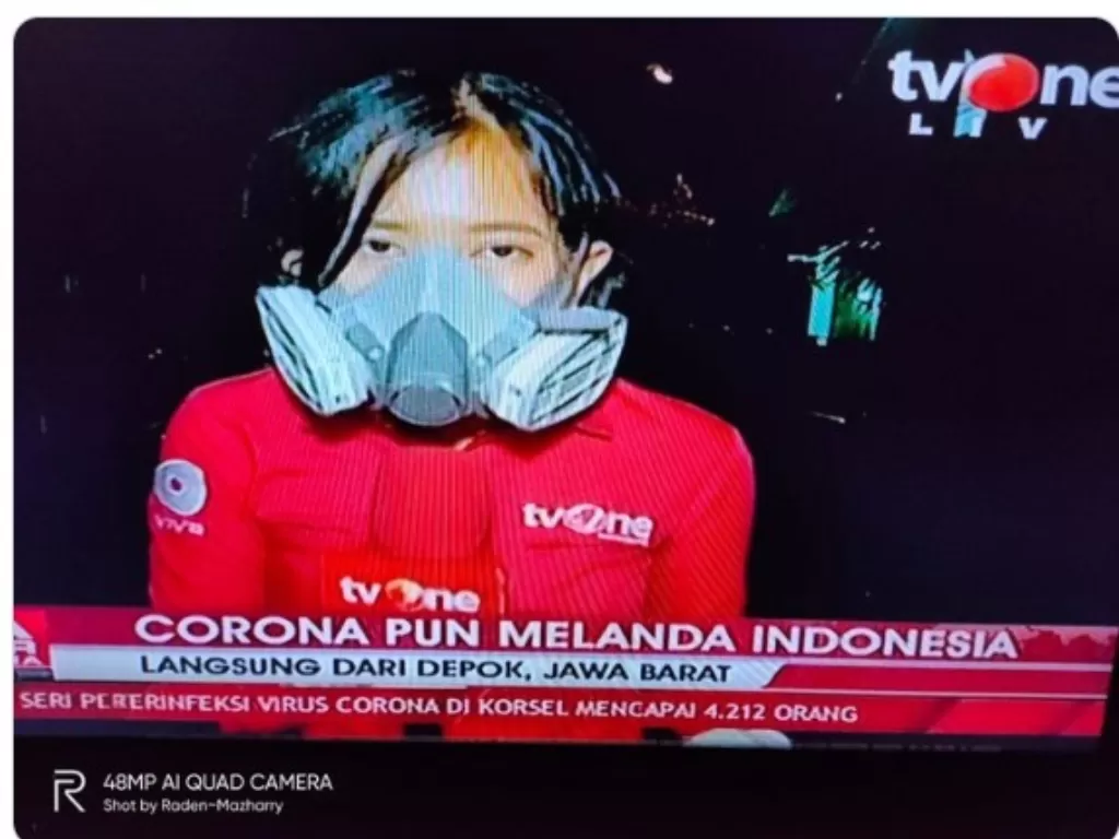 Jurnalis TvOne mengenakan masker respirator saat live di rumah korban terinfeksi corona (Twitter/@hericz)