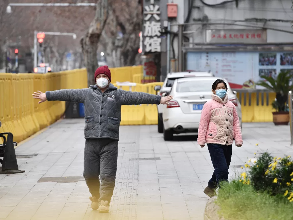 Ilustrasi: Seorang pria bermasker di Wuhan berolahraga (REUTERS/Stringer CHINA OUT)