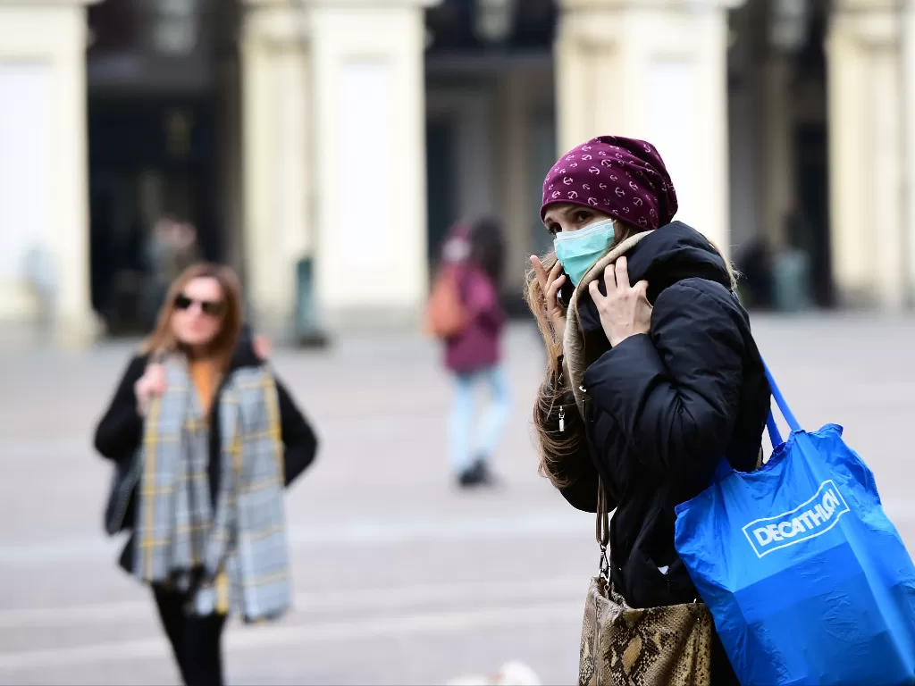 Ilustrasi - seorang wanita mengenakan masker. (photo/Reuters/Massimo Pinca)
