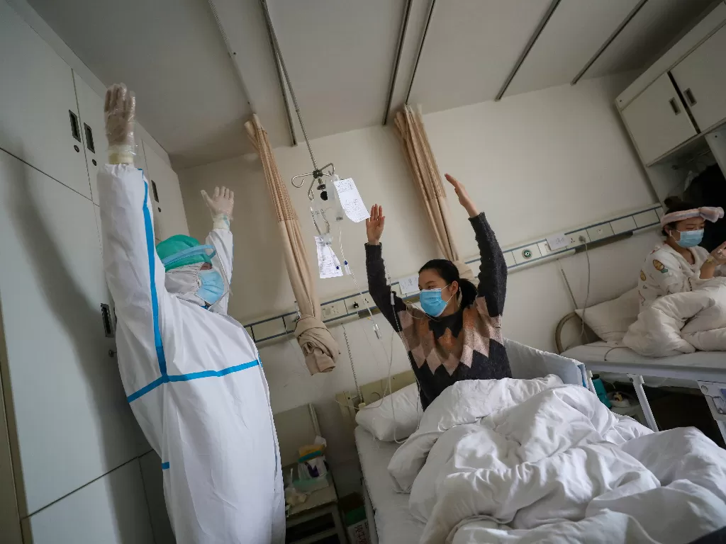 Petugas medis yang sedang melakukan perawatan kepada pasien virus corona di Wuhan. (photo/Reuters/China Daily)